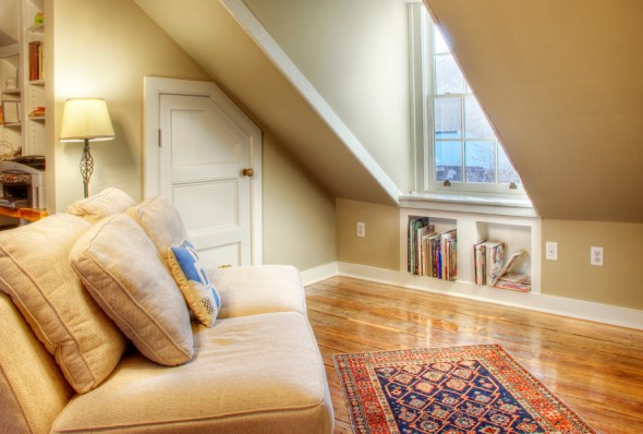 This fourth floor attic-space was converted into a lounge and office space. The "half-coffin" door seen in the back allows for storage space under the roof eave. Books nestle in a built-in below the window